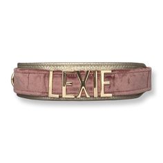 a pink belt with the word'exie'in gold on it and an embellishment