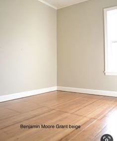 an empty room with hard wood floors and white paint on the walls, in front of a window