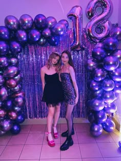 two young women standing in front of balloons