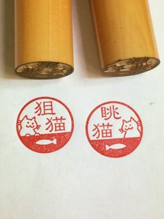 two stamps with chinese characters on them are placed next to each other in front of a white background