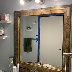 a bathroom with a sink, toilet and mirror in it's corner area that is being remodeled