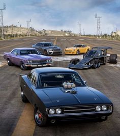 four muscle cars are lined up in a parking lot