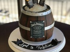 there is a cake made to look like a barrel with three bottles on top and the name jack daniels next to it