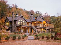 a large house in the woods with stairs leading up to it's second story