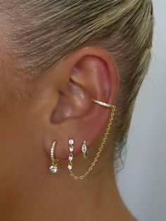 a woman wearing gold ear cuffs with white stones