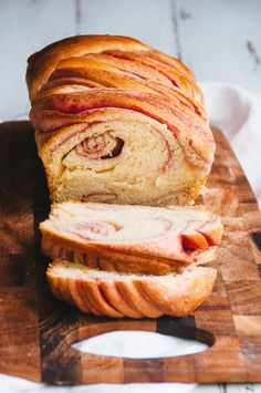 a sliced loaf of bread sitting on top of a wooden cutting board