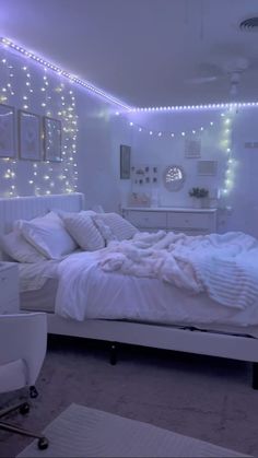 a white bedroom with lights on the walls