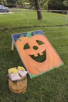 a pumpkin painted on the ground next to a barrel