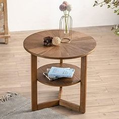 a wooden table with a magazine on it and flowers in the vase next to it