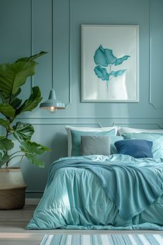 a bed with blue sheets and pillows next to a potted plant in a room