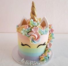 there is a cake that looks like a unicorn's head with flowers on it