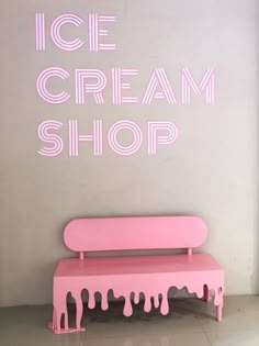 the ice cream shop sign is pink and has dripping icing on it's sides