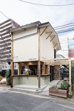 an old building with some tables and chairs on the outside, next to a street