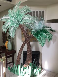 a fake palm tree in the middle of a living room with tile flooring and white walls