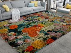 a living room filled with lots of furniture and flowers on the rug in front of it