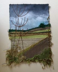 a piece of fabric with grass and trees in the background, on a wall next to a window