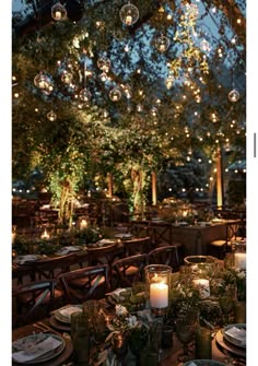 the tables are set with candles, plates and place settings for an outdoor dinner party