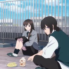 two people sitting on the ground next to each other with food in front of them