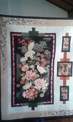 a quilted wall hanging with flowers and birds