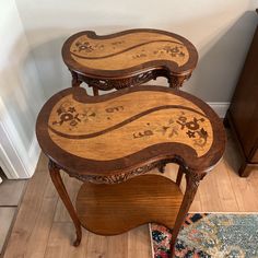 two wooden tables sitting next to each other on top of a hard wood flooring