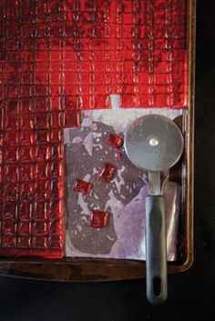 a spoon and some red squares on a wall