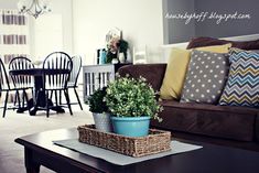 a living room filled with furniture and a wooden table topped with a potted plant