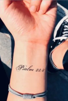 a woman's wrist tattoo with the word faith on it