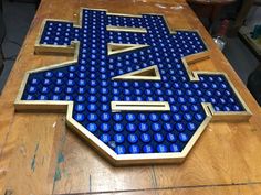 a wooden table topped with blue and gold letters