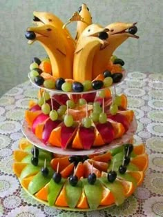 two tiered trays filled with fruit on top of a table