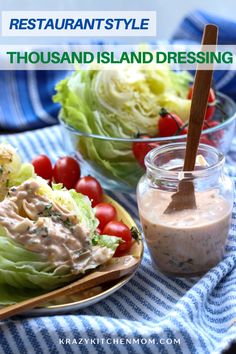 two plates with lettuce, tomatoes and dressing on them next to a jar of dressing