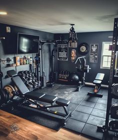 a home gym with black walls and lots of equipment