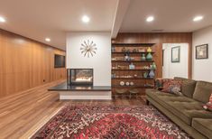 a living room with a couch, coffee table and fire place in the middle of it