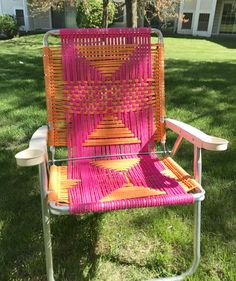 an orange and pink chair sitting in the grass