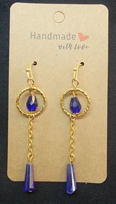 a pair of earrings with blue crystals hanging from it