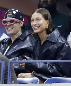 a man and woman sitting next to each other at a baseball game