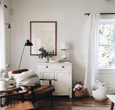 a living room with white walls and wooden floors