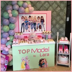 a model by lara themed dessert table with balloons and pictures on the wall behind it