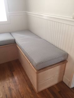 a wooden bench sitting in the corner of a room