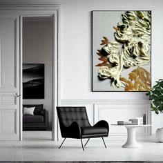 a living room with two chairs and a painting on the wall