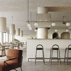 an empty restaurant with bar stools and lamps hanging from the ceiling, along with tables and chairs