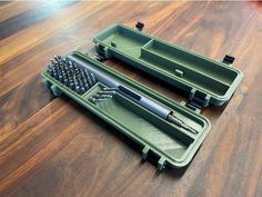 two green cases with different types of hair brushes in them on a wooden floor next to each other