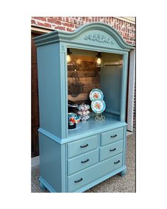 a blue china cabinet with plates on top