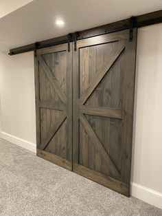 an empty room with two wooden doors and carpeted flooring on the side wall