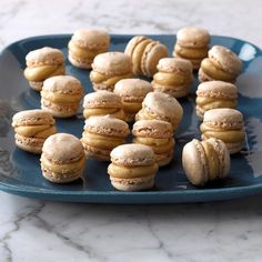 a blue plate topped with macaroons on top of a marble counter