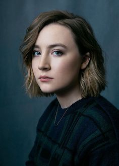 a woman with shoulder length hair and blue eyes is looking at the camera while wearing a black sweater