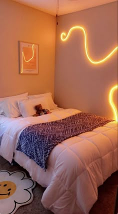 a bedroom with a bed, rug and neon lights on the wall above it that is shaped like an elephant