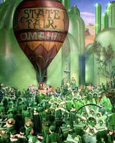 a large group of people standing in front of a hot air balloon with the words state fair on it