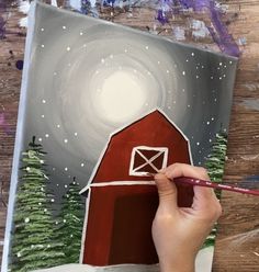 someone is painting a red barn with trees on it