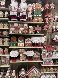 christmas decorations and gingerbread cookies are on shelves in a store display case with santa's helpers