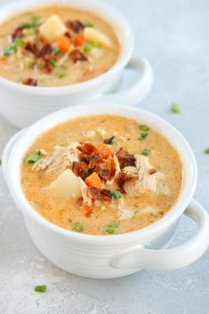 two white bowls filled with soup on top of a table